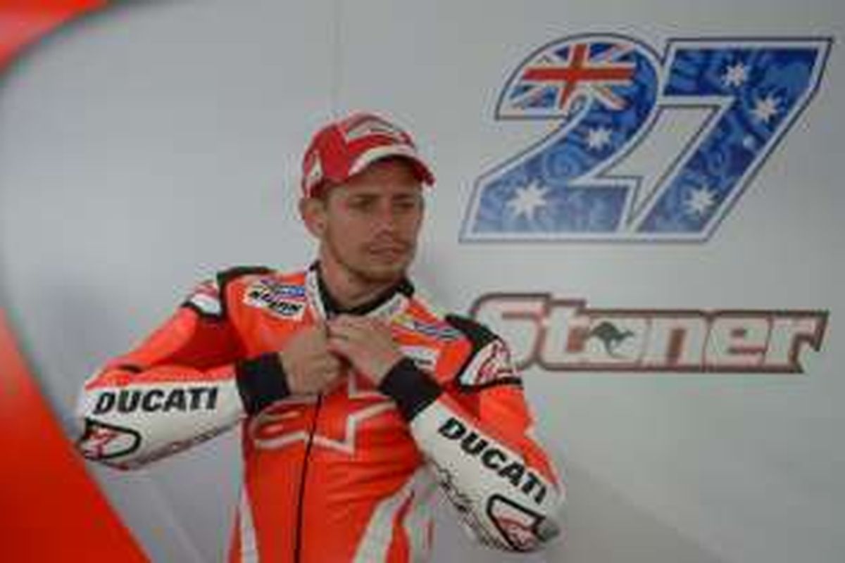 Pebalap penguji Ducati asal Australia, Casey Stoner, mengancingkan bajunya sebelum turun pada tes pramusim pertama di Sirkuit Sepang, Malaysia, Selasa (2/2/2016).