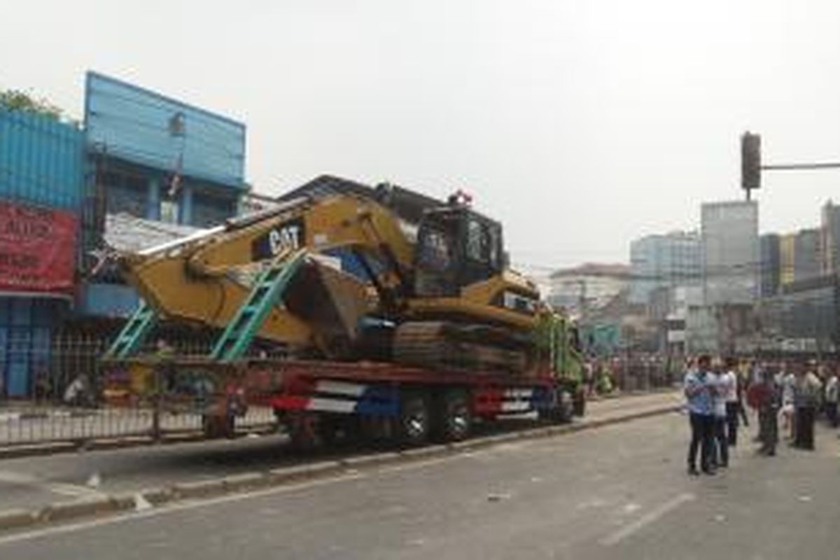 Satu unit eksavator baru yang didatangkan ke lokasi penertiban permukiman warga di Kampung Pulo, Jatinegara, Jakarta Timur, Kamis (20/9/2015). Eksavator kuning ini akan menggantikan eksavator sebelumnya yang rusak akibat dibakar warga.