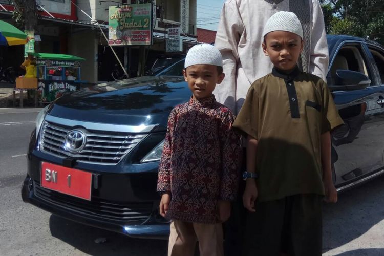 Musa (kanan) serta adiknya berposes di depan mobil dinas gubernur Kepulauan Bangka Belitung.