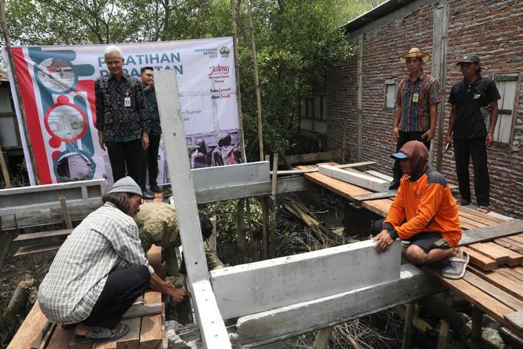 Gubernur Jawa Tengah Ganjar Pranowo meninjau program 34 paket bantuan rumah sistem panel instan (ruspin) untuk korban bencana rob di Desa Bedono, Kecamatan, Sayung, Kabupaten Demak, Selasa (14/3/2023).