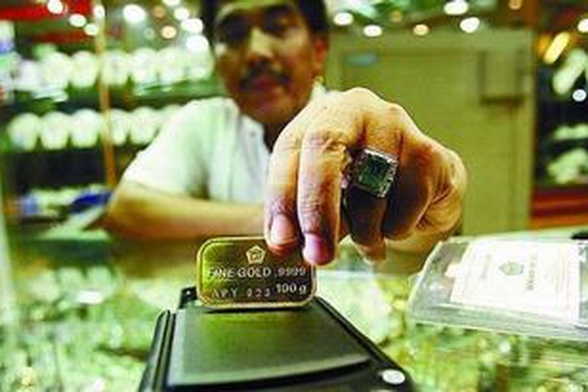 Pedagang emas di Pasar Tebet, Jakarta Selatan, menimbang emas murni batangan 100 gram. 