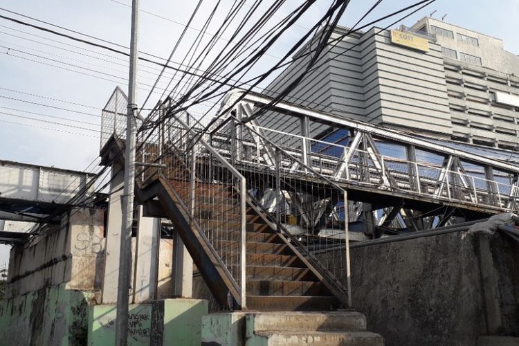 Kabel listrik diikat di jembatan penyeberangan orang (JPO) yang menghubungkan Jalan Gunung Sahari dengan Stasiun Kampung Bandan. Foto diambil Kamis (6/9/2018).