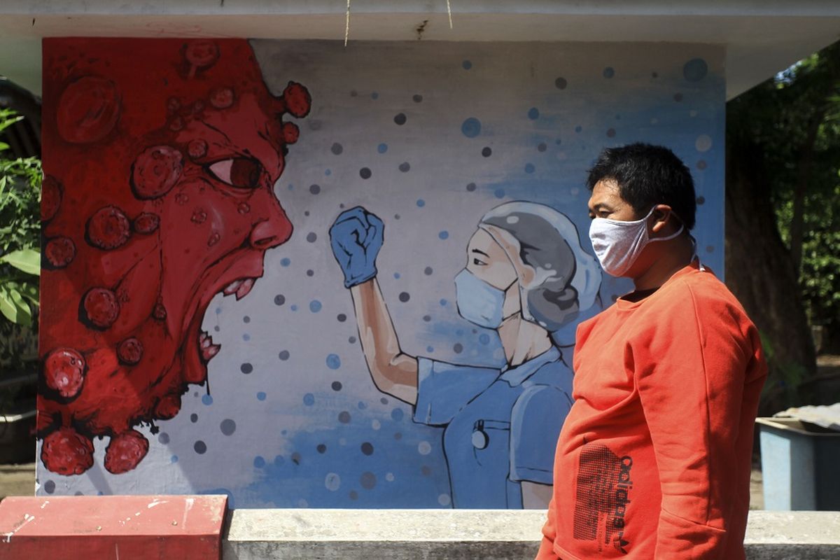 Warga melintas di dekat mural bergambar tenaga medis dan Virus Corona di kawasan Bantul, Yogyakarta, Selasa (23/6/2020). Mural yang dibuat oleh warga itu mengingatkan warga agar waspada terhadap Covid-19 sekaligus mendukung perjuangan tenaga medis yang menjadi garis terdepan dalam penanganan COVID-19. 