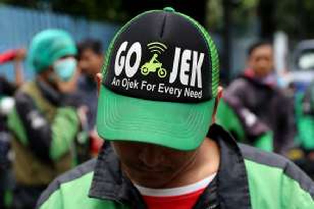 Seorang pengemudi Go-Jek menunggu aksi unjuk rasa di depan kantor manajemen PT Go-Jek, Kemang, Jakarta Selatan, Senin (3/10/2016). Mereka menuntut PT Go-Jek Indonesia untuk menghapus performa, membuat payung hukum yang independen dari keluhan pengemudi, transparansi dalam setiap kebijakan, menstabilkan sistem menjadi lebih baik dan memberikan kebijakan tarif yang rasional untuk semua pengemudi se-Indonesia.