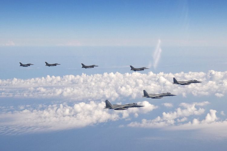 Dalam foto yang disediakan oleh Staf Gabungan Pasukan Bela Diri Jepang ini, tiga pesawat tempur F-15 Pasukan Bela Diri Jepang, depan, dan empat pesawat tempur F-16 Angkatan Bersenjata A.S. terbang di atas Laut Jepang pada hari Rabu , 25 Mei 2022.