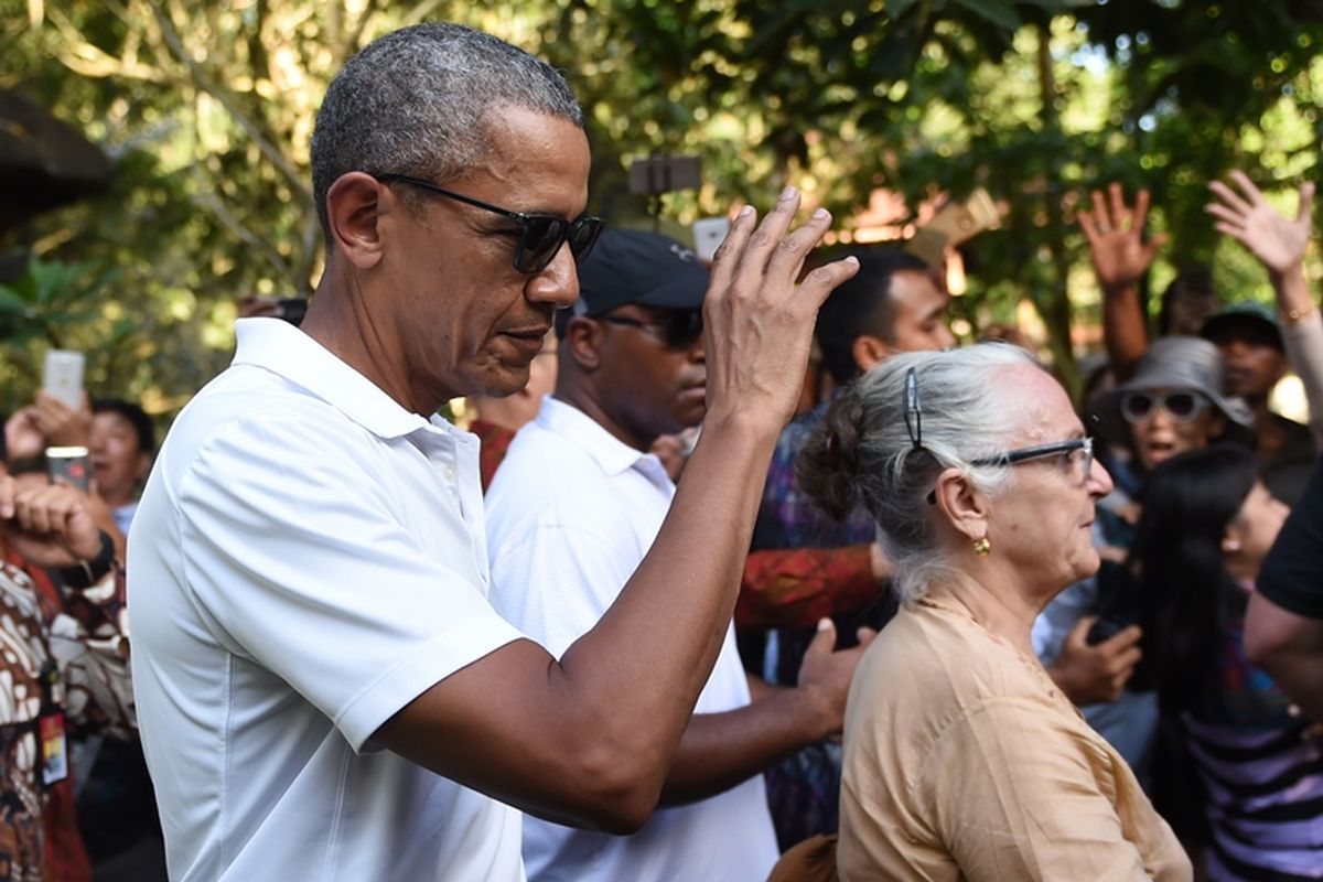 Mantan Presiden AS Barack Obama merespons sambutan publik saat mengunjungi Pura Tirtha Empul di Desa Tampaksiring, Gianyar, Bali, Selasa (27/6/2017). Obama berlibur selama 10 hari di Indonesia, yaitu di Bali dan Jakarta, kota tempatnya menghabiskan masa kecil. Demikian disampaikan oleh pihak berwenang, 24 Juni.