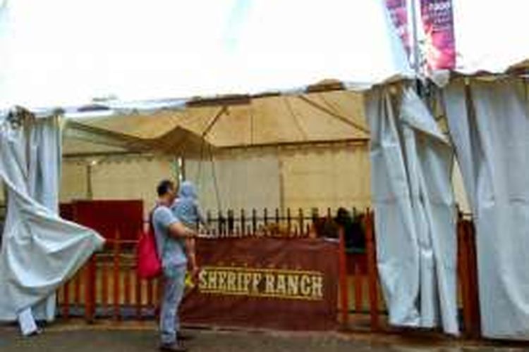 Seoramg bapak sedang menggending anaknya dindeoan Sherif Ranch, arena kebun binatang mini di Pekan Raya Indonesia.