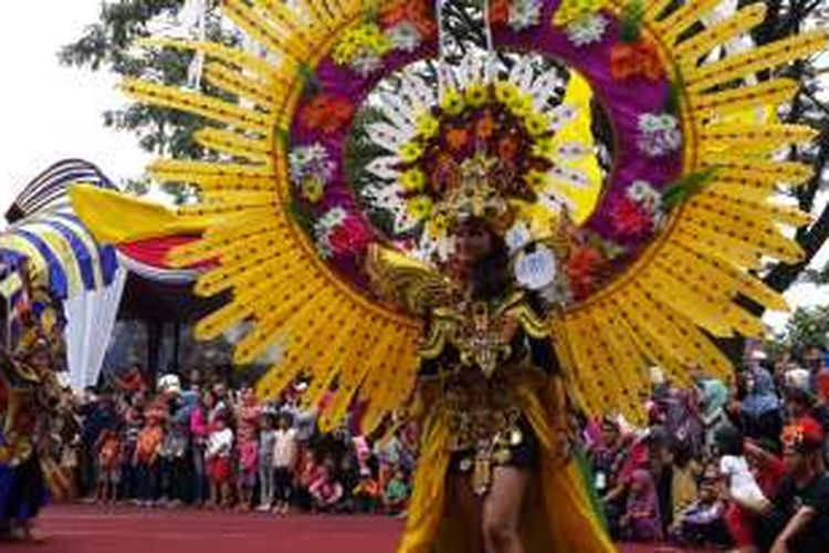 Salah satu peserta Malang Flower Carnival (MFC) memperagakan kostum yang dikenakannya, Minggu (4/9/2016), di Kota Malang, Jawa Timur.