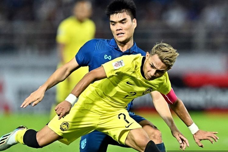 Penyerang Malaysia, Faisal Halim (7) dibayangi oleh pemain Thailand Peeradol Chamrasamee dalam laga leg kedua semifinal Piala AFF 2022 di Stadion Thammasat, Bangkok, 10 Januari 2023. (Photo by Lillian SUWANRUMPHA / AFP)