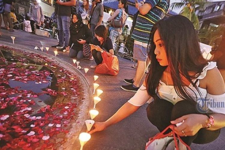 Seorang wisatawan turut menyalakan lilin dalam upacara peringatan 15 Tahun Bom Bali sekaligus launching buku Luka Bom Bali: Kisah Nyata dari Kejadian Bom di Bali di areal Ground Zero Kuta, Badung, Kamis (12/10/2017). 