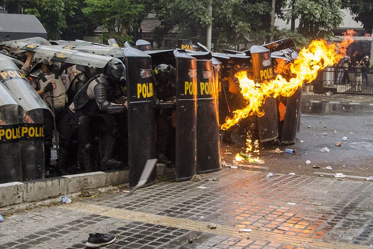 Personel kepolisian menahan lemparan molotov oleh demonstran saat unjuk rasa tolak Undang-Undang Cipta Kerja di Depan Gedung DPRD Jawa Barat, Bandung, Jawa Barat, Rabu (7/10/2020). Aksi yang menolak dan menuntut pembuatan Perppu untuk Undang-Undang Cipta Kerja tersebut berakhir ricuh.