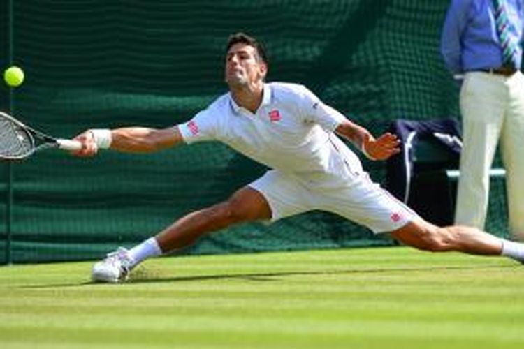Petenis Serbia, Novak Djokovic, berusaha mengembalikan bola ke arah petenis Kroasia, Marin Cilic, pada laga perempat final Wimbledon di London, Rabu (2/7/2014). Djokovic menang 6-1, 3-6, 6-7(4), 6-2, 6-2.