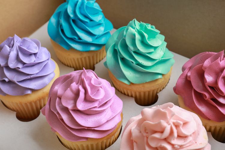 ilustrasi cupcakes dengan whipped cream warna warni. 