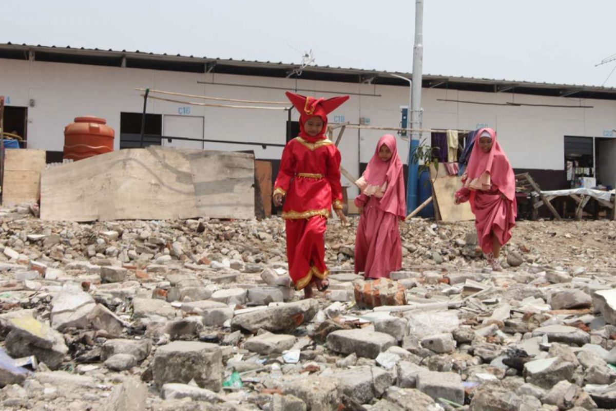 Sejumlah warga melintas di shelter Kampung Akuarium , Penjaringan, Jakarta, Sabtu (14/4/2018). Peringatan yang  bertajuk Dari Shelter Menuju Harapan Kampung yang Baru tersebut menampilkan pertunjukan warga kampung seperti musik dan tarian daerah.