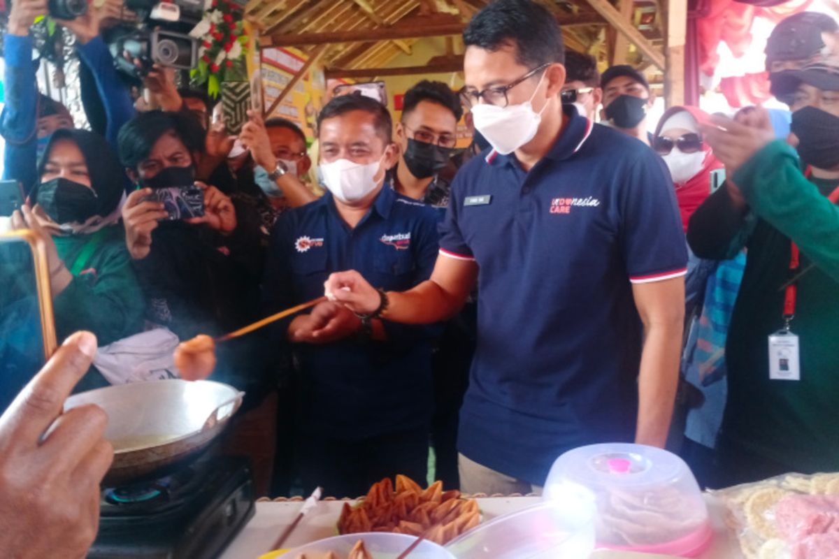 Menteri Parekraf Sandiaga Uno mencoba menggoreng Burayot, makanan khas Garut saat mengunjungi Desa Wisata Cangkuang, Minggu (22/08/2021)