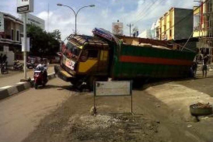 Sejumlah warga di Kabupaten Bone, Sulawesi Selatan berupaya mengevakuasi truk yang terperosok lantaran menghindari jalan rusak. Jumat, (19/07/2013).