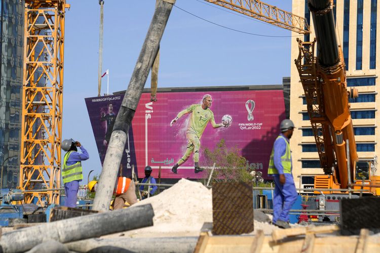 Sebuah billboard bergambar kiper Kosta Rika Keylor Navas dan kiper Belgia Thibaut Courtois ditampilkan di latar belakang saat para pekerja bekerja di Doha, Qatar, Sabtu (12/11/2022).