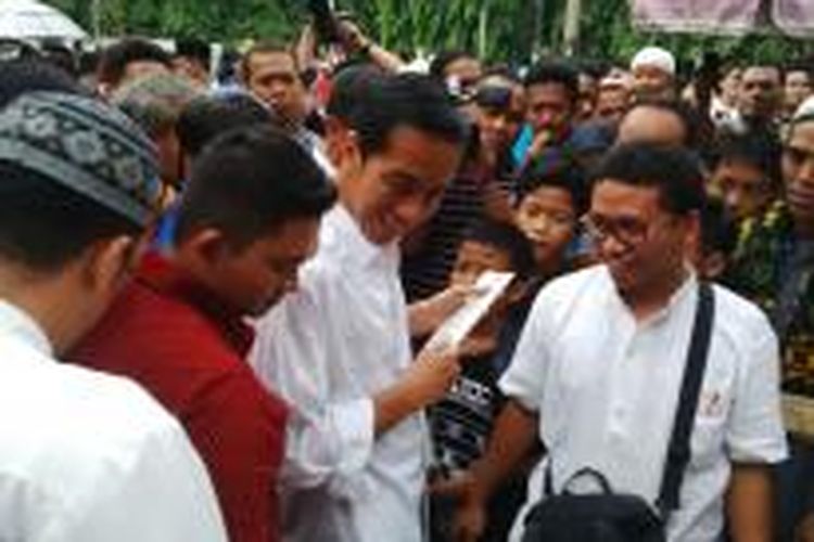 Gubernur DKI Jakarta Joko Widodo membeli gunting di depan Masjid Sunda Kelapa, Jumat (18/4/2014)