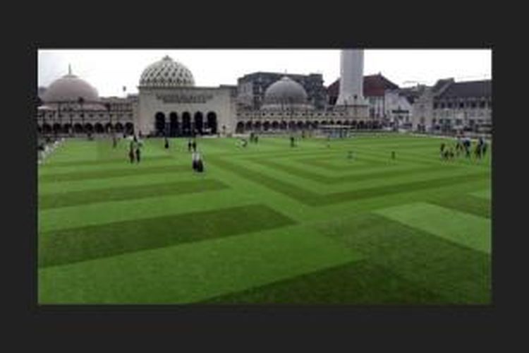 Warga berkesempatan mencoba berjalan-jalan dan bermain bola di atas rumput sintetis Taman Alun-Alun, Kota Bandung, Selasa (23/12). Proses pengerjaan taman tersebut masih dalam penyempurnaan sebelum diresmikan pada akhir tahun ini. 