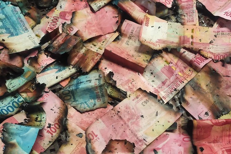Sukidi menunjukkan uang yang masih tersisa di rumahnya di Pedukuhan Tegalrejo, Kalurahan Hargowilis, Kapanewon Kokap, Kabupaten Kulon Progo, Daerah Istimewa Yogyakarta. Uang itu pun sudah rusak karena terbakar.