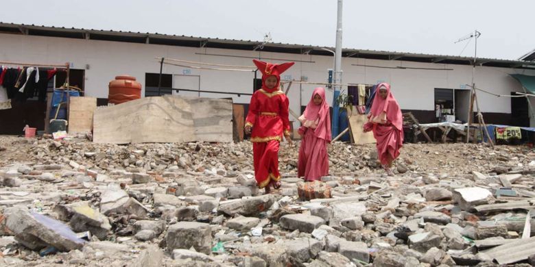 Sejumlah warga melintas di shelter Kampung Akuarium , Penjaringan, Jakarta, Sabtu (14/4/2018). Peringatan yang  bertajuk Dari Shelter Menuju Harapan Kampung yang Baru tersebut menampilkan pertunjukan warga kampung seperti musik dan tarian daerah.