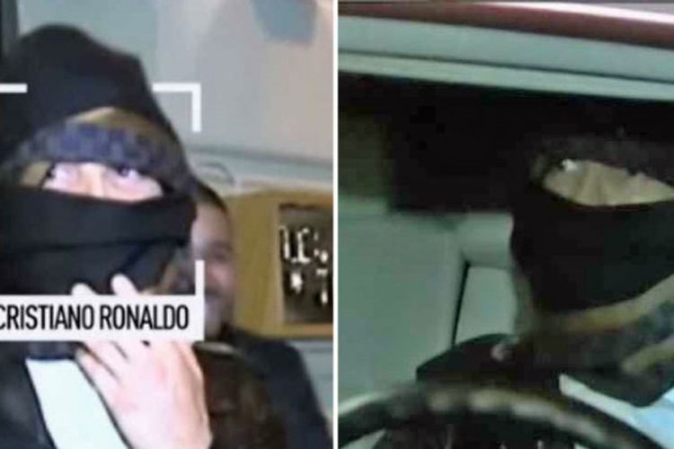 Cristiano Ronaldo menutupi wajahnya saat keluar dari sebuah restoran di kota Madrid.