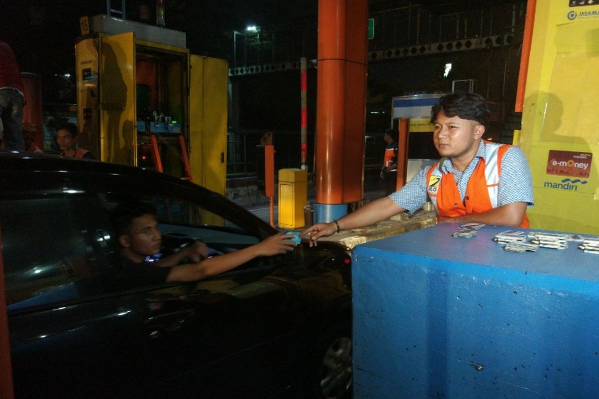 Petugas memberikan kartu tol kepada pengendara di Gerbang Tol (GT) Cibubur Ruas Tol Jagorawi sebelum GT ini dinonaktifkan dalam rangka integrasi jalan tol, Jumat (8/9/2017) pukul 00.00 WIB. 