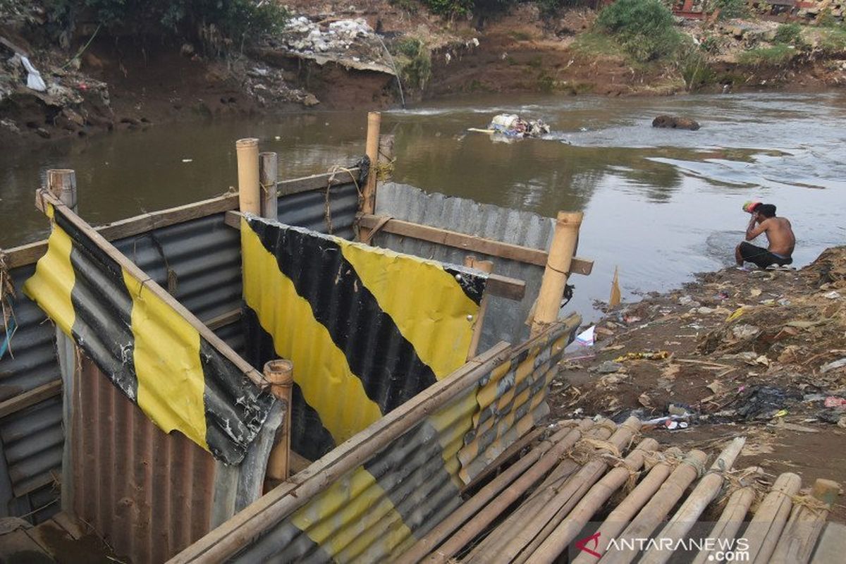 Seorang warga mandi di dekat bilik kakus atau jamban di kawasan Kampung Melayu, Jakarta, Rabu (16/10/2019). Pemerintah Provinsi DKI Jakarta mengajukan anggaran Rp10 miliar untuk memberantas kebiasaan buang air besar atau BAB sembarangan melalui program rehabilitasi septic tank dalam Kebijakan Umum Anggaran-Prioritas Plafon Anggaran Sementara (KUA-PPAS) untuk rancangan APBD DKI 2020.