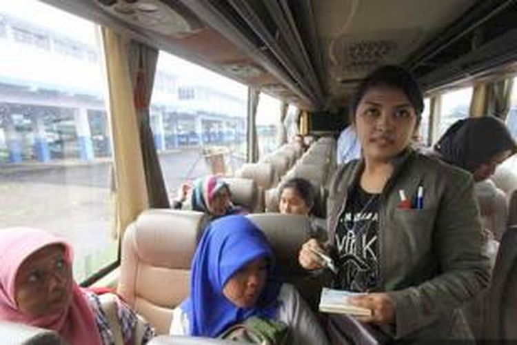 Kondektur perempuan asal Banyuwangi, Jawa Timur, Ira Sahisna Dewi saat menarik ongkos bus jurusan Trenggalek-Banyuwangi di Terminal Arjosari, Kota Malang, Minggu (1/2/2015). 
