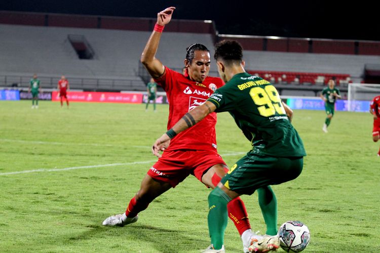 Pemain Persija Jakarta Ryuji Utomo menghalau bola pemain Persebaya Surabaya saat pertandingan pekan 25 Liga 1 2021-2022 yang berakhir dengan skor 3-3 di Stadion Kapten I Wayan Dipta Gianyar, Senin (14/2/2022) malam.