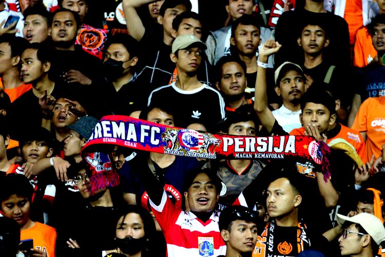 Seorang suporter Persija Jakarta membentangkan syal saat pertandingan pekan ke-7 Liga 1 2022-2023 melawan Arema FC yang berakhir dengan skor 0-1 di Stadion Kanjuruhan Kepanjen, Kabupaten Malang, Minggu (28/8/2022) malam.