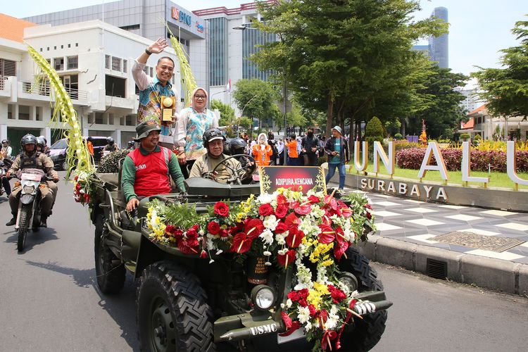 Mengendarai mobil Jeep, Walkot Eri didampingi Ketua TP PKK Surabaya, Rini Indriyani, memimpin arak-arakan Adipura Kencana bersama sejumlah penghargaan lain di bidang lingkungan hidup.