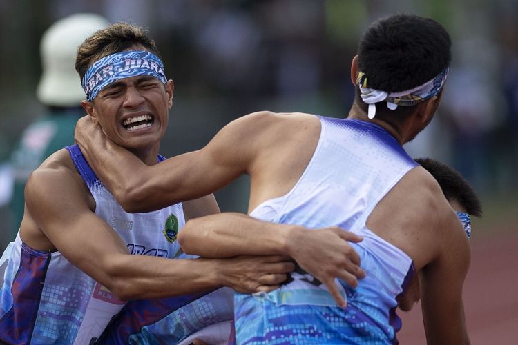 Pelari Jawa Barat M. Ramdhan Fitri (kiri) berpelukan dengan rekan-rekannya usai menang dalam final lari 4x400 meter estafet putra PON Papua di Stadion Atletik Mimika Sport Center, Kabupaten Mimika, Papua, Kamis (14/10/2021). Tim Jawa Barat meraih medali emas, sementara tim Jawa Timur meraih medali perak dan tim Jawa Tengah meraih medali perunggu. ANTARA FOTO/Aditya Pradana Putra/tom. 
