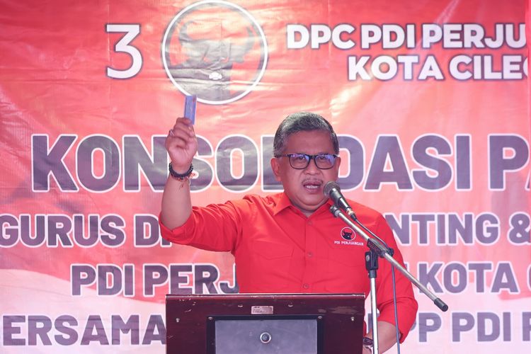 Sekretaris Jenderal PDI-P Hasto Kristiyanto mengangkat KTP miliknya saat menjelaskan salah satu program Ganjar-Mahfud, yaitu KTP Sakti di Kota Cilegon, Banten, Senin (11/12/2023) siang.
