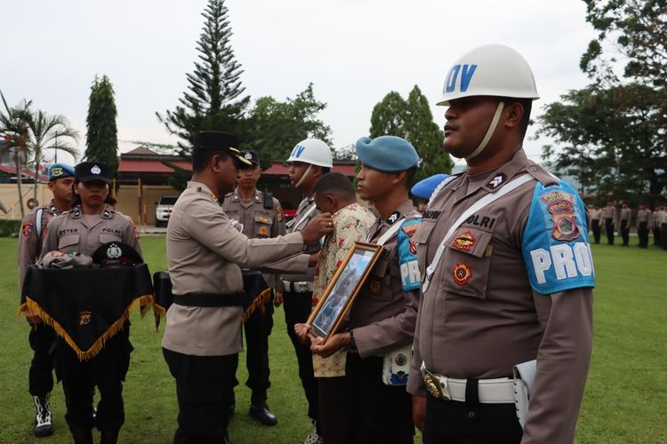 Kapolres Jayapura, Fredrickus W.A Maclarimboen, saat membuka baju dinas dari kedua anggota Polri yang bertugas di Polres Jayapura disela-sela upacara PTDH yang berlangsung di halaman Mapolres Jayapura, Jumat (31/3/2023).