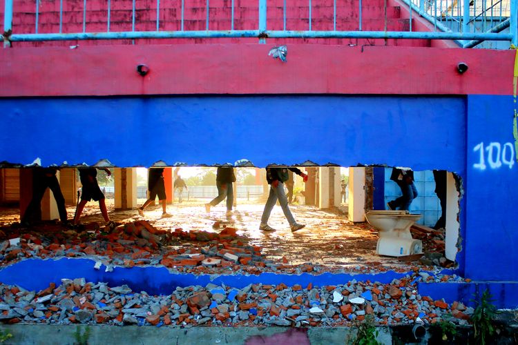 Sejumlah orang melewati bangunan yang dibongkar saat memperingati satu tahun Tragedi Kanjuruhan di Stadion Kanjuruhan Kepanjen Kabupaten Malang, Minggu (1/10/2023) sore. Sebelumnya stadion bagian dalam ditutup untuk umum guna proses hukum.