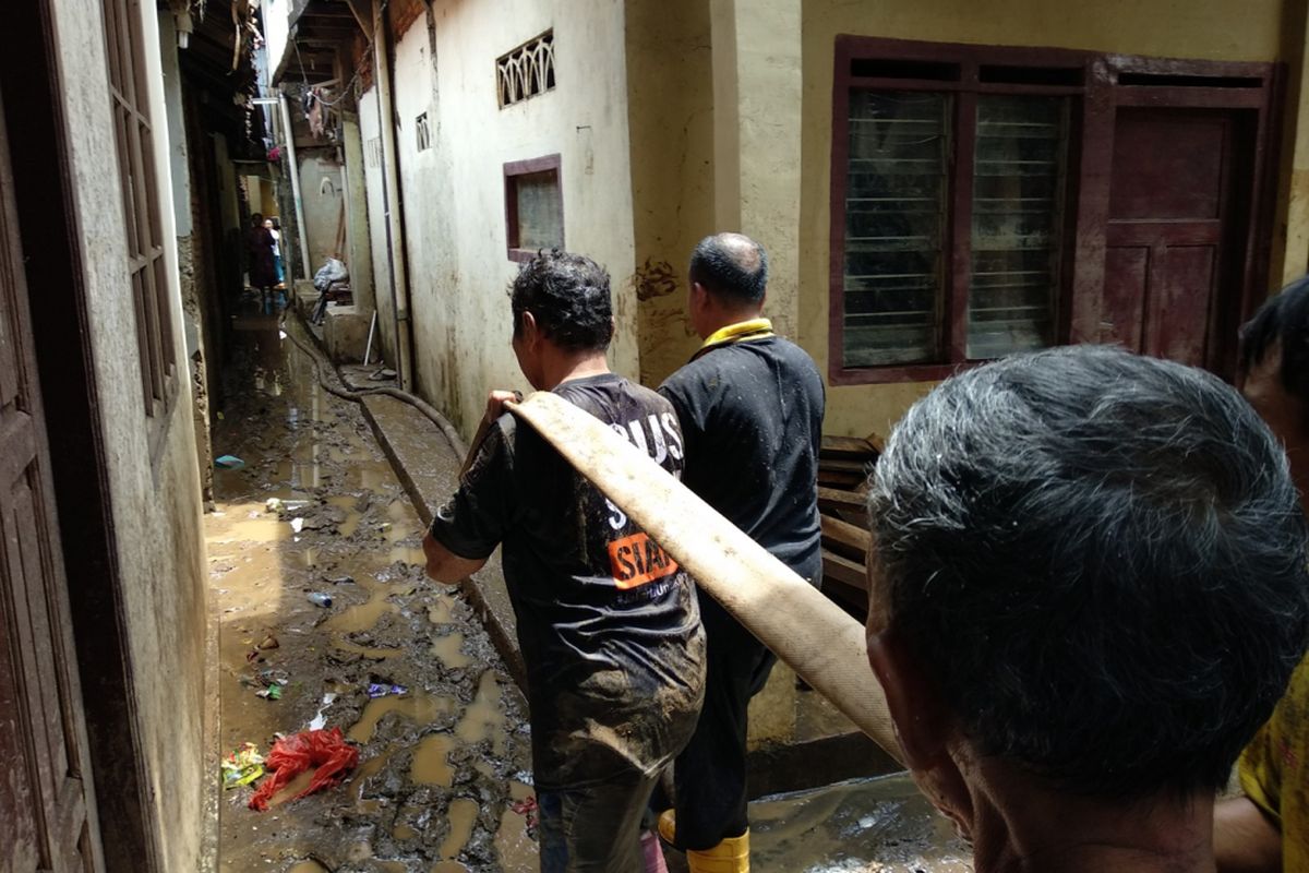 Warga Bidaracina membersihkan kawasan rumahnya dari bekas banjir, Jumat (9/2/2018)