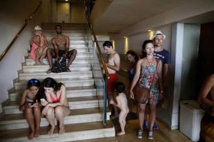 Warga Israel dan wisatawan berlindung di sebuah hotel setelah mereka berlari dari pantai di kota pesisir Tel Aviv, 14 Juli 2014, selama serangan roket yang ditembakkan oleh militan Palestina dari Jalur Gaza.