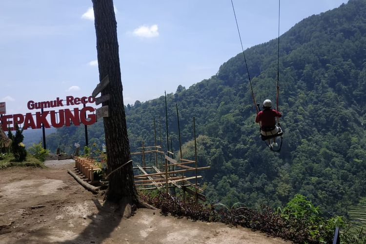 Pengunjung Gumuk Reco menikmati wahana Ayunan Langit.