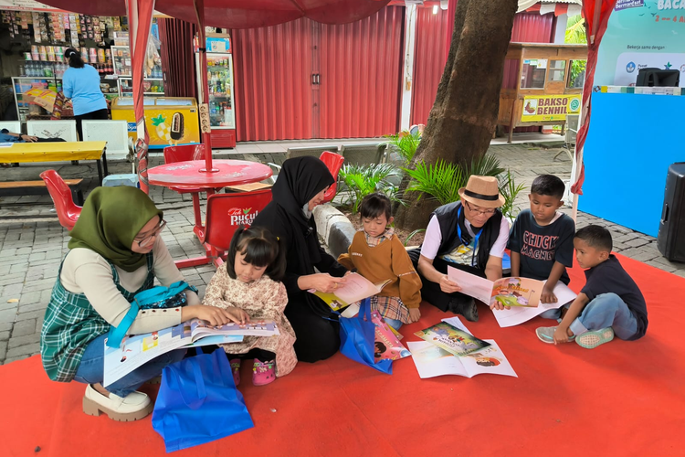 Sekretaris Badan Pengembangan dan Pembinaan Bahasa Kemendikbud Ristek, Hafidz Muksin, saat membagikan buku cetak ke anak-anak di Terminal Kalideres, Jakarta, Selasa (2/4/2024).