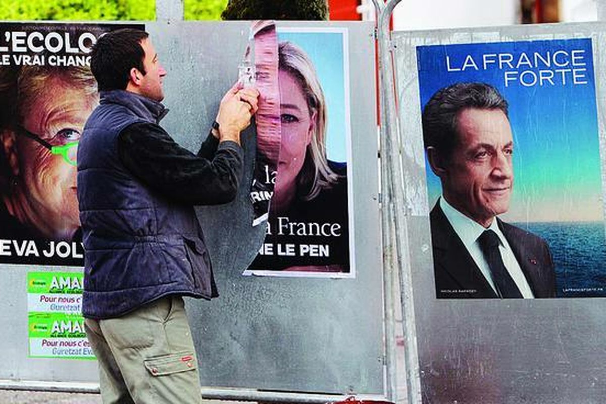 Petugas  mencopot poster pemimpin sayap kanan Perancis, Marine Le Pen, di La Bastide Clairence, Perancis barat daya, Selasa (24/4), seusai pemilihan presiden putaran pertama. Sehari setelah kandidat kubu sosialis Francois Hollande unggul tipis,  presiden petahana dari kubu konservatif, Nicolas Sarkozy, mengincar suara pendukung Le Pen, yang menempati urutan ketiga.