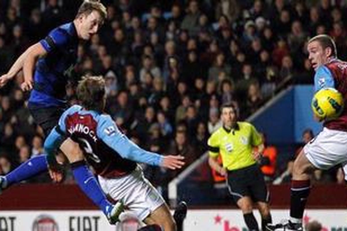 Bek Manchester United, Phil Jones (kiri), melepaskan tembakan, yang berujung gol ke gawang Aston Villa, pada pertandingan Premier League, di Villa Park, Minggu (4/12/2011) dini hari WIB.