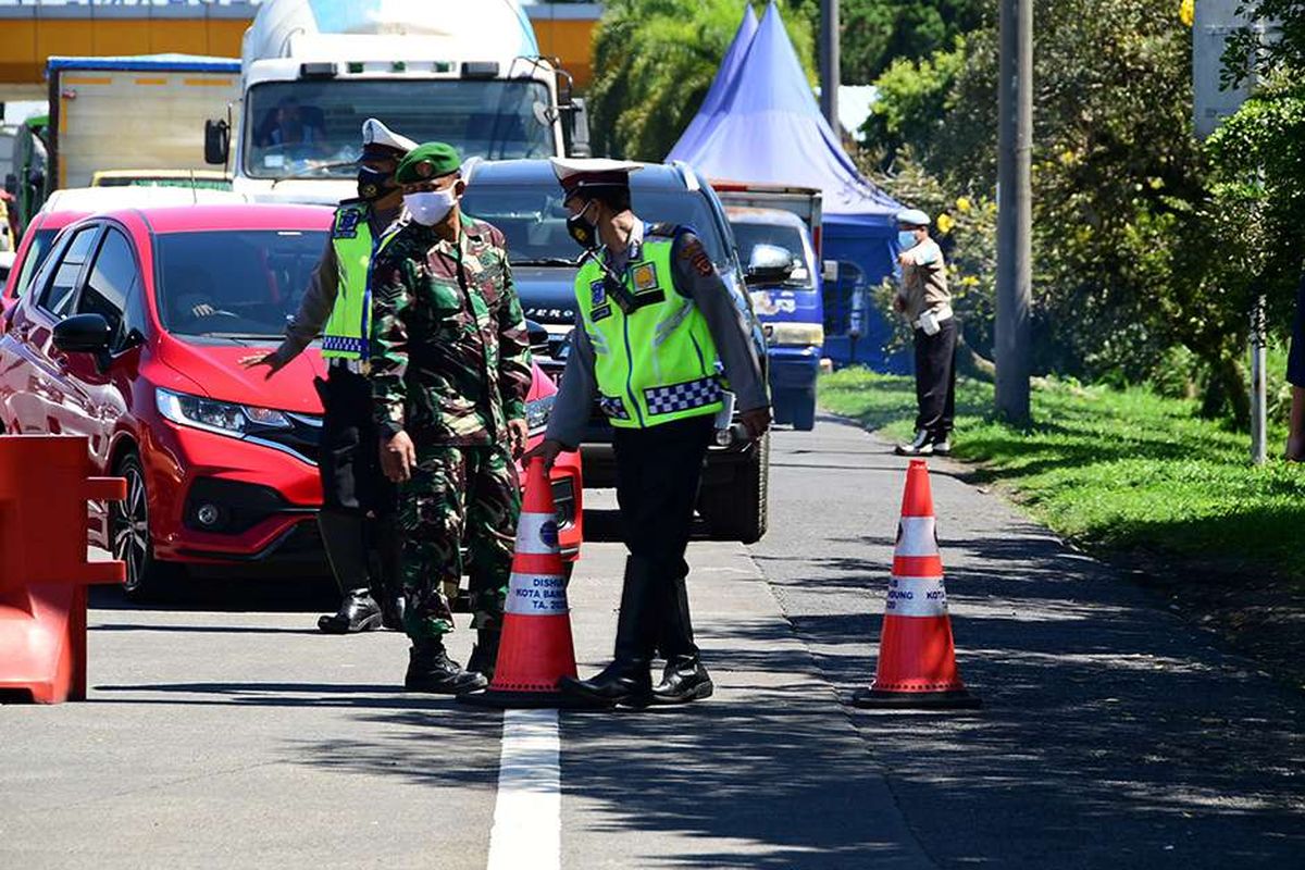 Petugas melakukan penyekatan kendaraan di depan Gerbang Tol Pasteur, Kota Bandung, Jawa Barat, Selasa (6/7/2021). Selama PPKM Darurat, Kota Bandung tertutup bagi warga dari luar wilayahnya, hal tersebut dilakukan untuk menekan mobilitas masyarakat dan mengurangi penyebaran Covid-19.