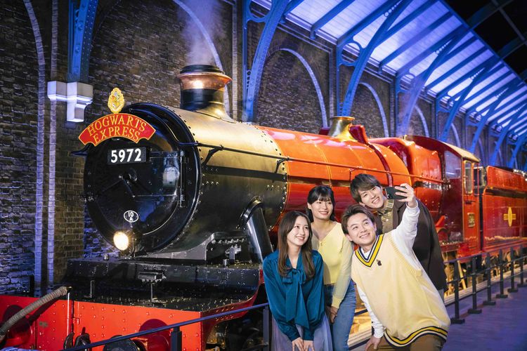 Ilustrasi pengunjung berfoto di depan Hogwarts Express di Warner Bros. Studio Tour Tokyo- The Making of Harry Potter di Jepang.
