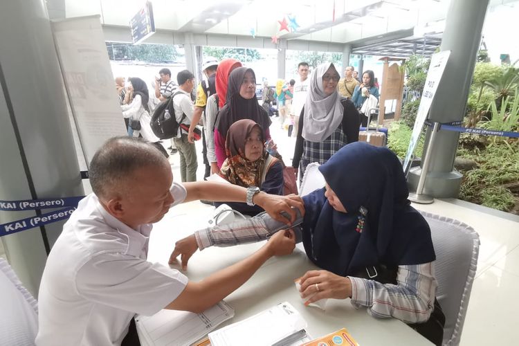 Petugas memeriksa kesehatan penumpang di Stasiun Pasar Senen, Jakarta, Senin (30/12/2019). PT KAI Daop 1 Jakarta membuka layanan kesehatan gratis pada musim liburan Natal Tahun Baru.