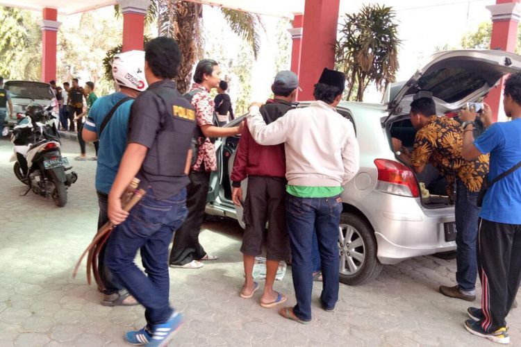 Anggota Reskrim Polres Bangkalan mengamankan warga yang membawa senjata tajam di halaman kantor ULP Bangkalan.