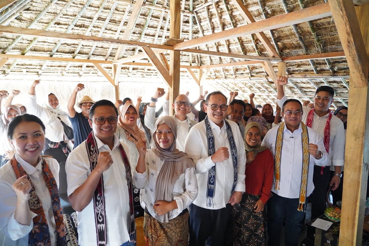 Direktur Utama Permodalan Nasional Madani (PNM) Kindaris (tengah) berfoto bersama warga Desa Sade dan juga perwakilan PNM yang mendampinginya setelah menyalurkan bantuan alat tenun.