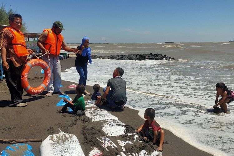 Ketua Pokdarwis Objek Wisata Pulo Kodok Kota Tegal Kasiran beserta anggotanya memberikan peringatan kepada pengunjung agar tidak mandi di laut karena ombak sedang tinggi, Jumat (21/8/2020)