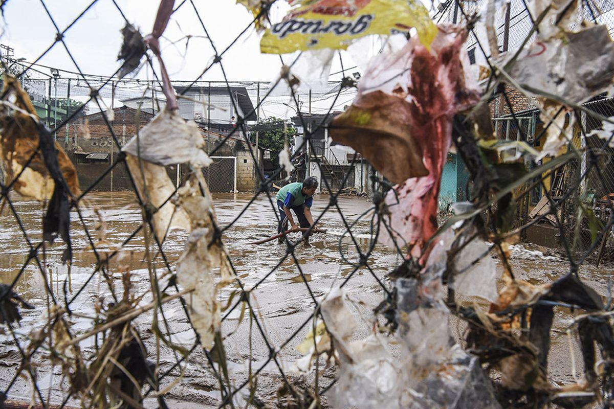 Warga membersihkan lapangan futsal dari endapan lumpur pascabanjir di kawasan Kelurahan Rawajati, Jakarta, Senin (29/4/2019). Warga mulai membersihkan rumahnya dari endapan lumpur pascabanjir yang melanda kawasan tersebut.