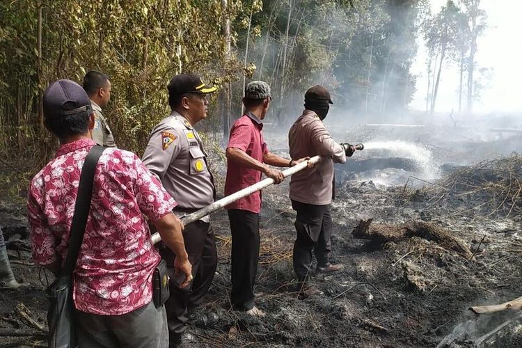 Petugas kepolisian dan aparat gabungan lainnya melakukan pemadaman karhutla di Riau beberapa hari lalu.